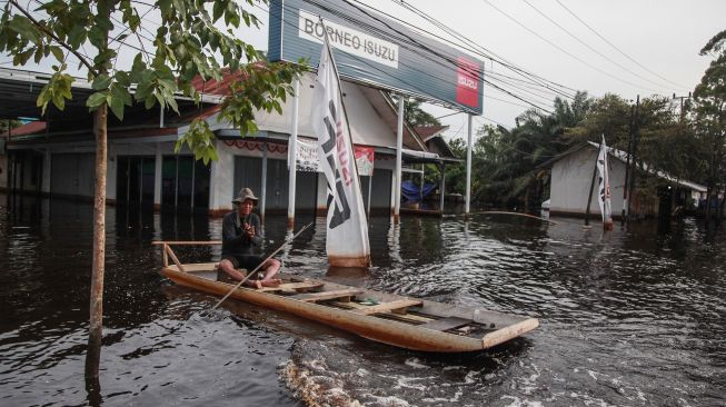 Warga menggunakan perahu untuk melintasi banjir yang merendam di kawasan Jalan Ahmad Yani , Pangkalan Bun, Kotawaringin Barat, Kalimantan Tengah, Selasa (1/11/2022). ANTARA FOTO/Makna Zaeza