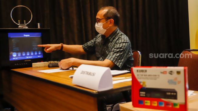 Petugas Kementerian Kominfo (Komunikasi dan Informatika) memberikan penjelasan penggunaan alat STB (Set Top Box) yang dibagikan secara gratis kepada warga di Posko Respon Cepat Penanganan Bantuan STB di Hotel Akmani, Jakarta Pusat, Kamis (3/11/2022). [Suara.com/Alfian Winanto]