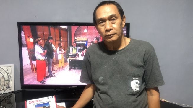 warga Petukangan Utara, Bahtiar memamerkan siaran televisi digital yang kini ditontonnya menggantikan siaran analog. [Suara.com/Faqih Faturrahman]