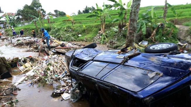 Kondisi mobil warga yang terseret banjir di Kalibaru, Banyuwangi, Jawa Timur, Jumat (4/11/2022). [ANTARA FOTO/Budi Candra Setya/foc].