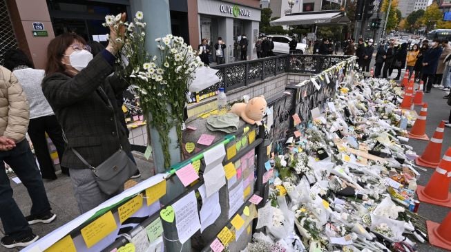 Pelayat menaruh bunga di monumen peringatan darurat untuk para korban Tragedi Itaewon di luar stasiun kereta bawah tanah di distrik Itaewon, Seoul, Korea Selatan, Kamis (3/11/2022). [Jung Yeon-je / AFP]