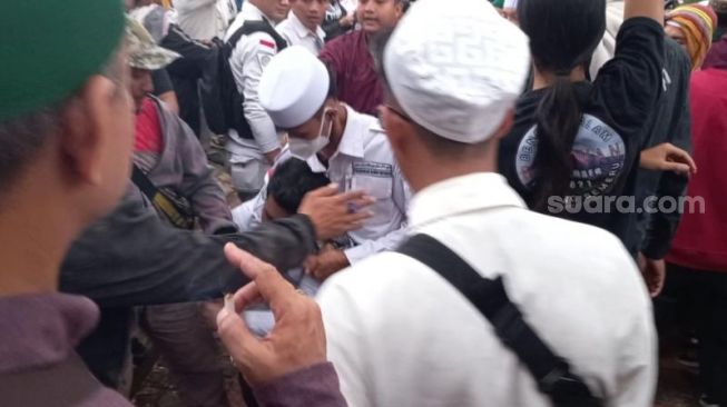 Laskar GNPR tampak mengamankan seorang peserta dalam keributan saat Aksi 411 di Patung Kuda, Jakarta Pusat, Jumat (4/112022). [Suara.com/Rakha Arlyanto]