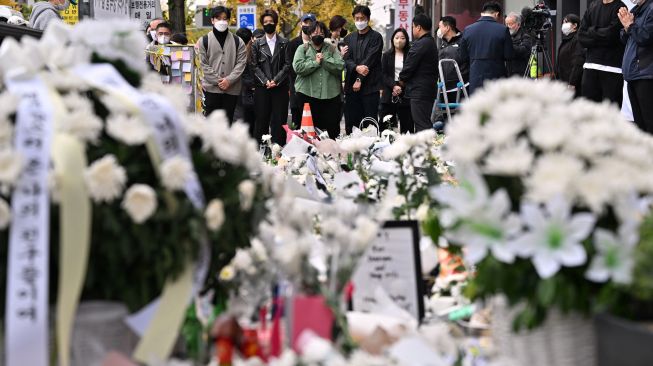 Para pelayat berdoa di monumen peringatan darurat untuk para korban Tragedi Itaewon di luar stasiun kereta bawah tanah di distrik Itaewon, Seoul, Korea Selatan, Kamis (3/11/2022). [Jung Yeon-je / AFP]
