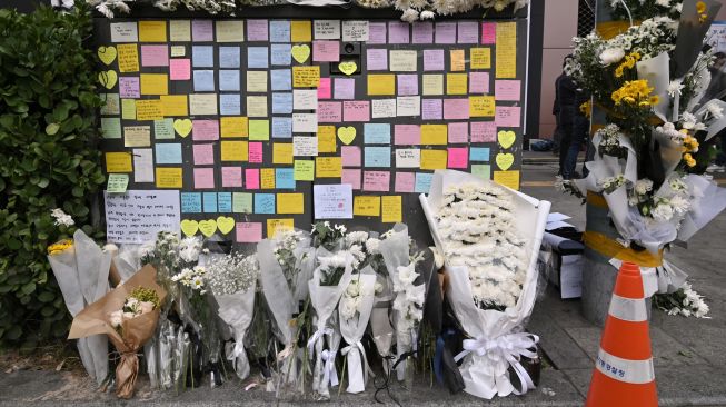 Bunga dan pesan dari pelayat terlihat di monumen peringatan darurat untuk para korban Tragedi Itaewon di luar stasiun kereta bawah tanah di distrik Itaewon, Seoul, Korea Selatan, Kamis (3/11/2022). [Jung Yeon-je / AFP]