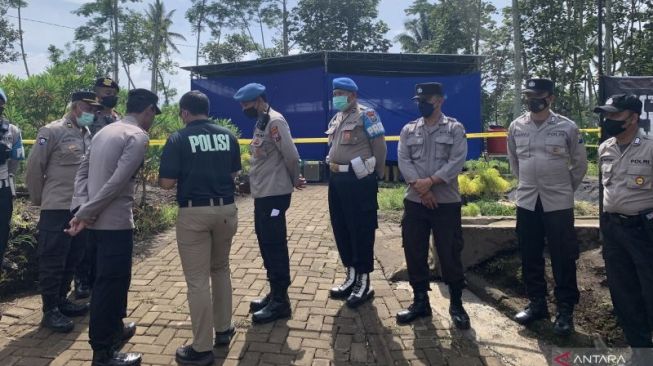 Polisi berjaga di lokasi autopsi di TPU Dusun Patuk, Desa Sukolilo, Kecamatan Wajak, Kabupaten Malang, Jawa Timur, Sabtu (5/11/2022). [ANTARA/Vicki Febrianto]