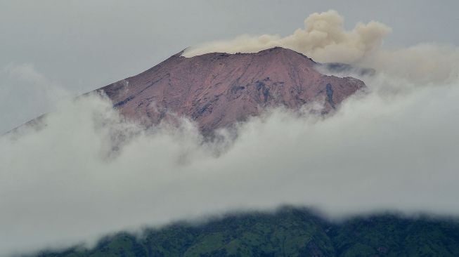 Gunung Kerinci mengembuskan gas dan material ke udara yang terlihat dari Kayu Aro, Kerinci, Jambi, Sabtu (5/11/2022). ANTARA FOTO/Wahdi Septiawan