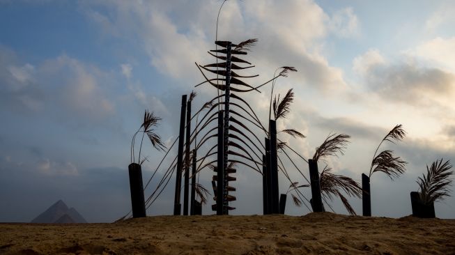 SPemandangan instalasi seni "Guardians Of The Wind" oleh seniman Saudi Mohammad Alfaraj saat ditampilkan di pameran Art D'Égypte "Forever is Now" di komplek Piramida Giza, Mesir, Kamis (27/10/2022). [Walaa AL-SHAER / ART DEGYPTE / AFP]