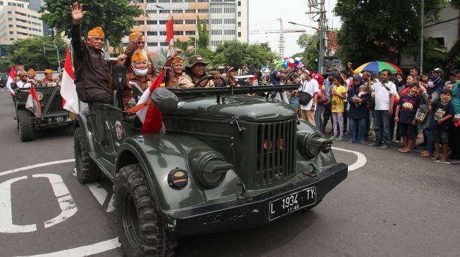 Warga menyaksikan konvoi mobil Jeep saat Parade Surabaya Juang di Surabaya, Jawa Timur, Minggu (6/11/2022). [ANTARA FOTO/Didik Suhartono/foc]