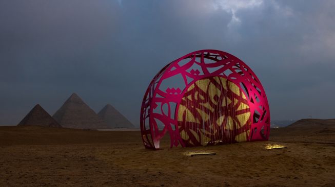 Pemandangan instalasi seni "Secrets of Time" karya seniman Tunisia El Seed ditampilkan saat pameran Art D'Égypte "Forever is Now" di komplek Piramida Giza, Mesir, November 4, 2022. (Photo by MOHAMMED ABED / AFP)