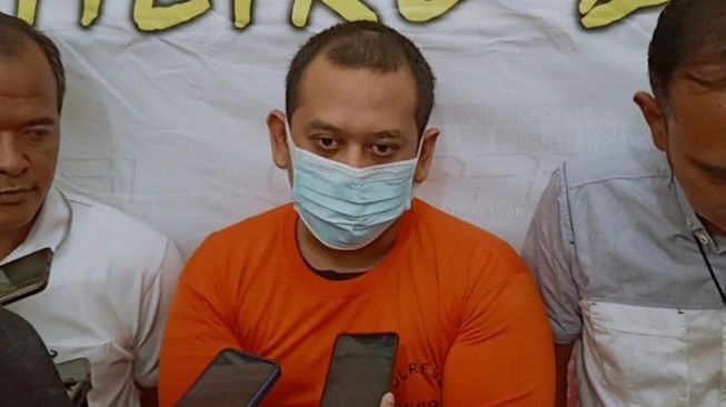 Rizky Noviandi Achmad (tengah), pelaku pembunuhan anak kandung dan penganiaya istrinya hingga kritis ketika diwawancarai wartawan di Polres Metro Depok (Depoktoday.com)