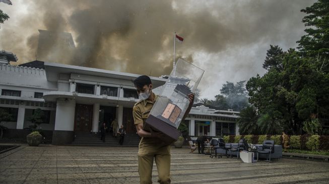 Seorang aparatur sipil negara menyelamatkan barang-barang dari lokasi kebakaran gedung Pemerintah Kota (Pemkot) Bandung di Balai Kota Bandung, Jawa Barat, Senin (7/11/2022). [ANTARA FOTO/Novrian Arbi/wsj].