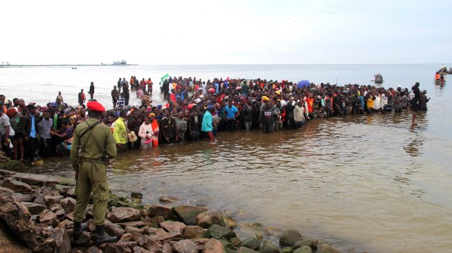 Penduduk setempat berkumpul saat tim penyelamat mencari korban selamat penumpang pesawat Precision Air yang jatuh di Danau Victoria di Bukoba, Tanzania, Minggu (6/11/2022). [SITIDE PROTASE / AFP]