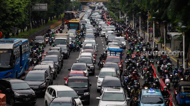 Sejumlah kendaraan bermotor menaiki trotoar saat melintas di Jalan Salemba Raya, Jakarta Pusat, Senin (7/11/2022). [Suara.com/Alfian Winanto]