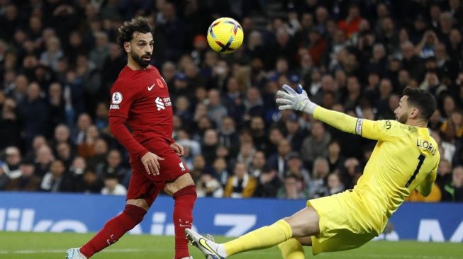 Striker Liverpool asal Mesir Mohamed Salah (kiri) mencetak gol dengan melepaskan tembakkan yang melewati kiper Tottenham Hotspur Hugo Lloris (kanan) selama matchday pekan ke-15 Liga Inggris 2022-2023 antara Tottenham Hotspur vs Liverpool di Stadion Tottenham Hotspur di London, pada 6 November 2022.Ian Kington / AFP.