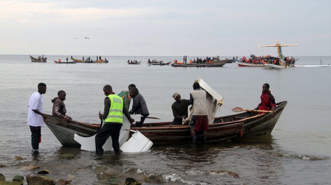 Tim penyelamat membawa puing-puing pesawat Precision Air yang jatuh di Danau Victoria di Bukoba, Tanzania, Minggu (6/11/2022). [SITIDE PROTASE / AFP]
