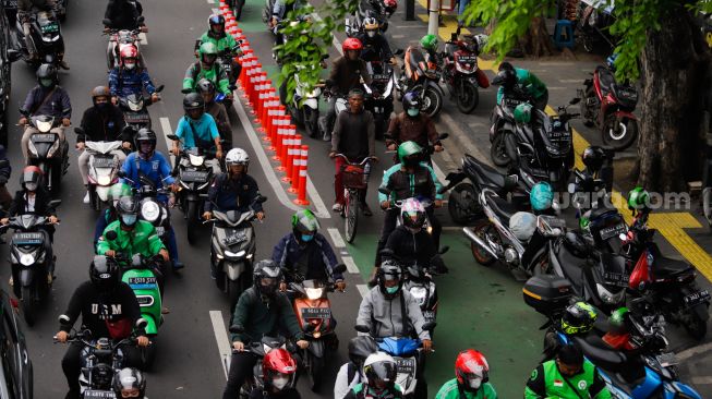 Pesepeda melintas di jalur sepeda bersama dengan kendaraan bermotor di Jalan Salemba Raya, Jakarta Pusat, Senin (7/11/2022). [Suara.com/Alfian Winanto]