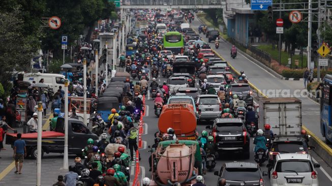 Sejumlah kendaraan bermotor menaiki trotoar saat melintas di Jalan Salemba Raya, Jakarta Pusat, Senin (7/11/2022). [Suara.com/Alfian Winanto]