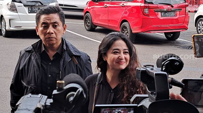 Dewi Perssik mengeluarkan senyum semringah saat tiba di Polres Metro Jakarta Selatan, Senin (7/11/2022). Depe hadir bersama pengacaranya, Sandy Arifin terkait kasus dengan haters yang menghinanya di media sosial. [Rena Pangesti/Suara.com]