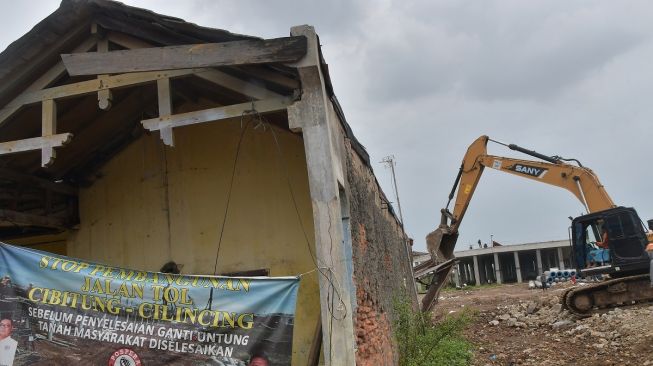 Petugas menggunakan alat berat untuk merobohkan bangunan rumah saat pembebasan lahan proyek Jalan Tol CIbitung-CIlincing seksi 4 di Semper Timur, Cilincing, Jakarta Utara, Selasa (8/11/2022). [ANTARA FOTO/ Fakhri Hermansyah/aww].