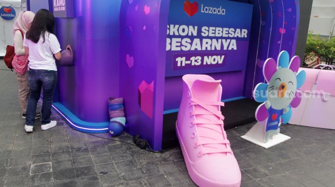 Pengunjung mencoba mesin diskon terbesar Festival belanja Lazada 11.11 Diskon Sebesar-besarnya di FX Sudirman, Jakarta. Selasa, (8/11/2022). [Suara.com/Oke Atmaja]