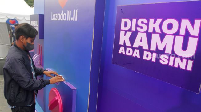 Pengunjung mencoba mesin diskon terbesar Festival belanja Lazada 11.11 Diskon Sebesar-besarnya di FX Sudirman, Jakarta. Selasa, (8/11/2022). [Suara.com/Oke Atmaja]