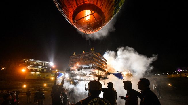 Orang-orang yang  melepaskan balon udara panas yang dilampirkan dengan kembang api selama Festival Cahaya Tazaungdaing di Pyin Oo Lwin, Mandalay, Myanmar, Minggu (6/11/2022).