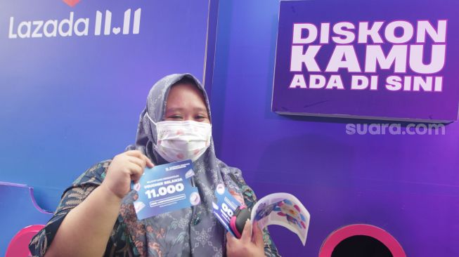 Pengunjung mencoba mesin diskon terbesar Festival belanja Lazada 11.11 Diskon Sebesar-besarnya di FX Sudirman, Jakarta. Selasa, (8/11/2022). [Suara.com/Oke Atmaja]