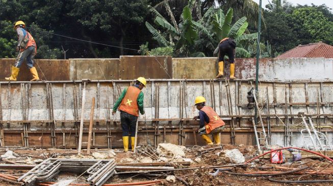 Pekerja menyelesaikan proses pembangunan underpass di Jalan Dewi Sartika, Depok, Jawa Barat, Rabu (9/11/2022). [Suara.com/Alfian Winanto]