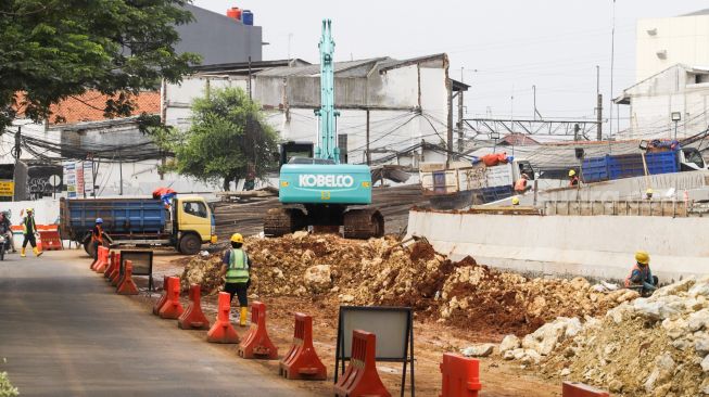 Pekerja menyelesaikan proses pembangunan underpass di Jalan Dewi Sartika, Depok, Jawa Barat, Rabu (9/11/2022). [Suara.com/Alfian Winanto]