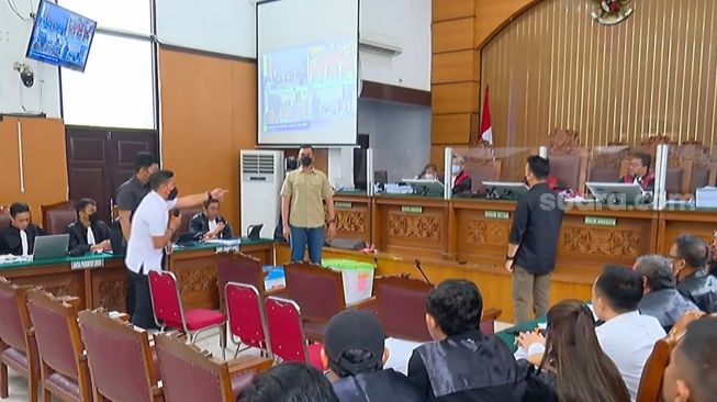 Saksi Adzan Romer diminta memeragakan adegan di sidang saat Yosua tewas dieksekusi di eks rumah dinas Ferdy Sambo di Kompleks Polri, Duren Tiga, Jaksel. (Suara.com/Arga)