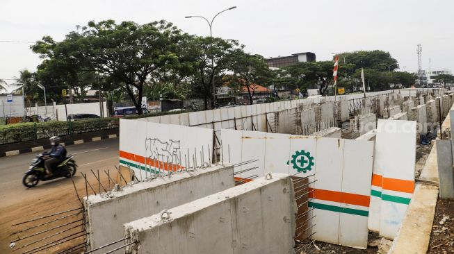 Pekerja menyelesaikan proses pembangunan underpass di Jalan Dewi Sartika, Depok, Jawa Barat, Rabu (9/11/2022). [Suara.com/Alfian Winanto]