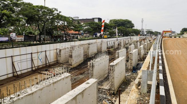 Pekerja menyelesaikan proses pembangunan underpass di Jalan Dewi Sartika, Depok, Jawa Barat, Rabu (9/11/2022). [Suara.com/Alfian Winanto]