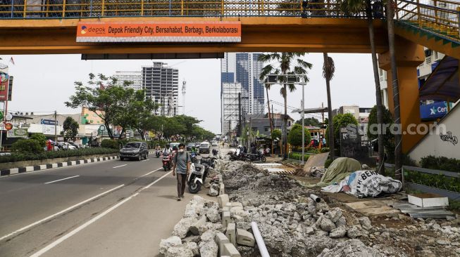 Warga berjalan di samping trotoar yang direvitalisasi di Jalan Margonda Raya, Depok, Jawa barat, Rabu (9/11/2022). [Suara.com/Alfian Winanto]