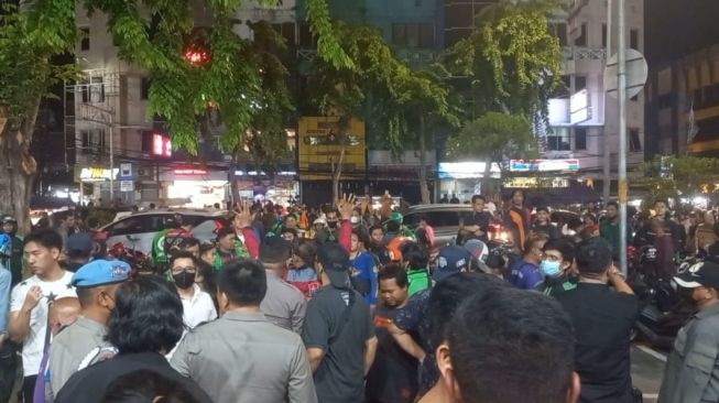 Ratusan driver Ojol menggeruduk Hotel Sumi di Jalan Taman Sari Jakarta Barat, pada Rabu (9/11/2022) malam, karena rekannya dipukul oleh seorang pria. Pria pelaku pemukulan itu lari ke hotel Sumi. [Suara.com/Faqih]