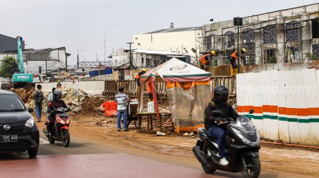 Pekerja menyelesaikan proses pembangunan underpass di Jalan Dewi Sartika, Depok, Jawa Barat, Rabu (9/11/2022). [Suara.com/Alfian Winanto]