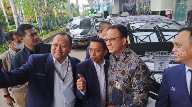 Capres Anies Baswedan saat berswafoto di lokasi HUT Partai NasDem. (Suara.com/Novian)