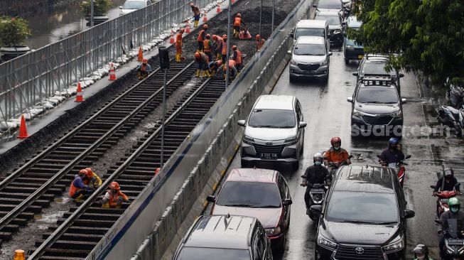 Pekerja melakukan pembongkaran aspal yang menutup jalur trem pada masa kolonial Belanda di lokasi proyek MRT Jakarta fase 2 di kawasan Jalan Gajah Mada, Jakarta Pusat, Kamis (10/11/2022). [Suara.com/Alfian Winanto]