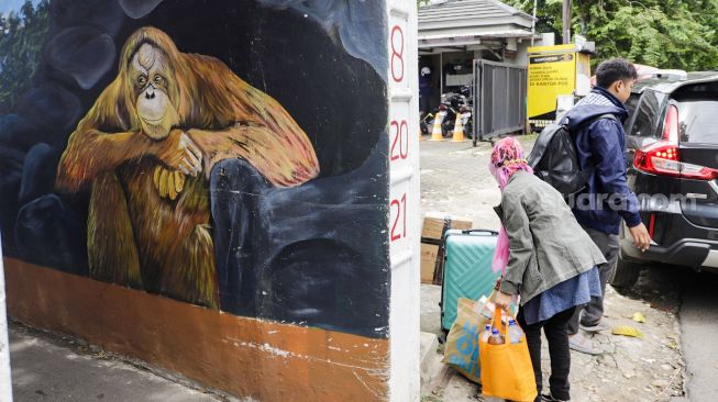 Warga melintas di gang Satria, Mampang, Jakarta Selatan, Kamis (10/11/2022). [Suara.com/Alfian Winanto]