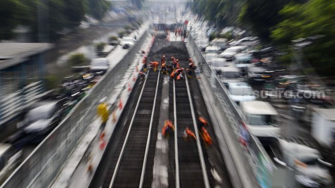 Pekerja melakukan pembongkaran aspal yang menutup jalur trem pada masa kolonial Belanda di lokasi proyek MRT Jakarta fase 2 di kawasan Jalan Gajah Mada, Jakarta Pusat, Kamis (10/11/2022). [Suara.com/Alfian Winanto]