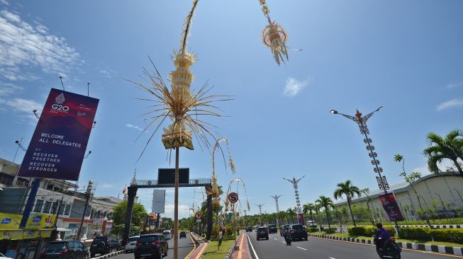 Kendaraan melintas di jalan yang pinggirnya dihiasi baliho KTT G20 dan penjor atau hiasan janur kuning khas Bali di Jalan Bandara Ngurah Rai, Kabupaten Badung, Bali, Kamis (10/11/2022).[ANTARA FOTO/Aditya Pradana Putra/nym].