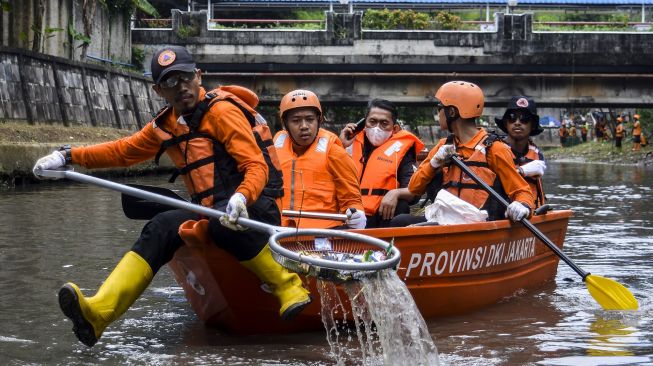 Sejumlah petugas Badan Penanggulangan Bencana Daerah (BPBD) DKI Jakarta mengambil sampah saat kerja bakti gabungan di Kali Ciliwung, Jakarta, Kamis (10/11/2022). [ANTARA FOTO/Sulthony Hasanuddin/YU]