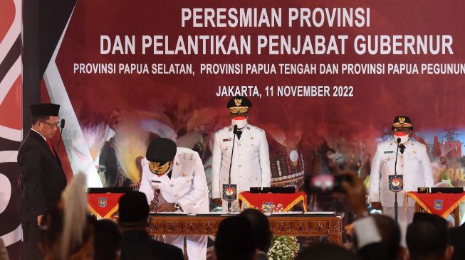 Menteri Dalam Negeri Tito Karnavian (kiri) menyaksikan penandatanganan berita acara pelantikan Penjabat Gubernur Provinsi Papua Selatan Apolo Safanpo (kedua kiri), Pj Gubernur Papua Pegunungan Nikolaus Kondomo (kedua kanan), dan Pj Gubernur Papua Tengah Ribka Haluk (kanan) di Kantor Kemendagri, Jakarta, Jumat (11/11/2022). [ANTARA FOTO/Indrianto Eko Suwarso/nz]