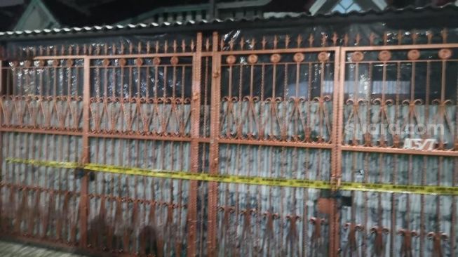 Rumah satu keluarga tewas di Kalideres, Jakarta Barat, dipasangi plastik di bagian depannya, Sabtu (12/11/2022). [Suara.com/Yosea Arga Pramudita]