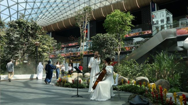 Musisi tampil di taman tropis yang ada di Bandara Internasional Hamad, Doha, Qatar, Kamis (10/11/2022). [KARIM JAAFAR / AFP]
