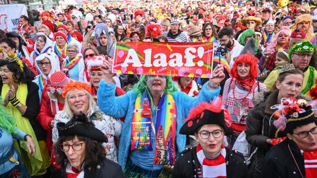 Orang-orang bersuka ria merayakan dimulainya musim karnaval "kelima" atau karnaval konyol di Cologne, Jerman, Jumat (11/11/2022). [INA FASSBENDER / AFP]