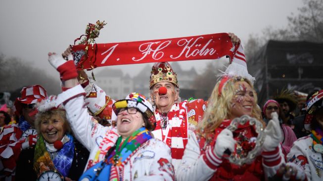 Orang-orang bersuka ria merayakan dimulainya musim karnaval "kelima" atau karnaval konyol di Cologne, Jerman, Jumat (11/11/2022). [INA FASSBENDER / AFP]