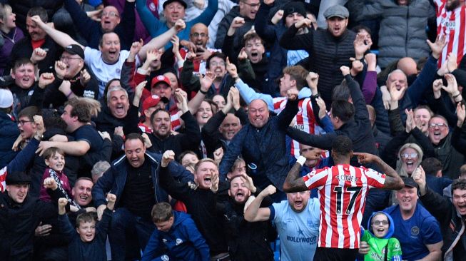 Striker Brentford Ivan Toney selebrasi di depan pendukung mereka setelah mencetak gol saat pertandingan sepak bola Liga Premier Inggris antara Manchester City dan Brentford di Stadion Etihad, Manchester, Inggris, Sabtu (12/11/2022). [Oli SCARFF / AFP]