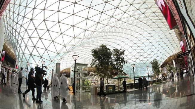 Wisatawan berfoto di taman tropis yang ada di Bandara Internasional Hamad, Doha, Qatar, Kamis (10/11/2022). [KARIM JAAFAR / AFP]