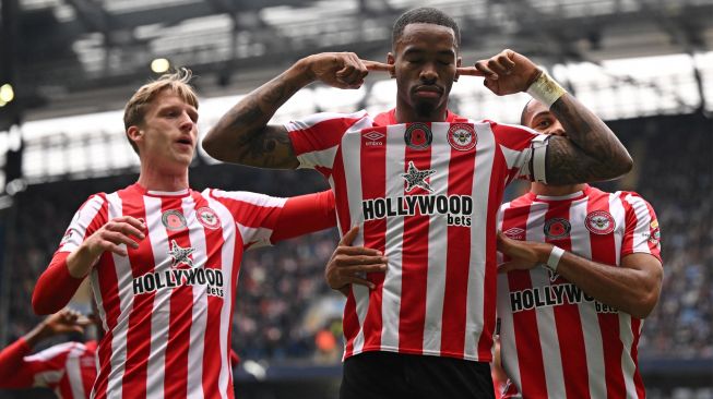 Striker Brentford Ivan Toney (Tengah) selebrasi dengan rekan setimnya setelah mencetak gol saat pertandingan sepak bola Liga Premier Inggris antara Manchester City dan Brentford di Stadion Etihad, Manchester, Inggris, Sabtu (12/11/2022). [Oli SCARFF / AFP]