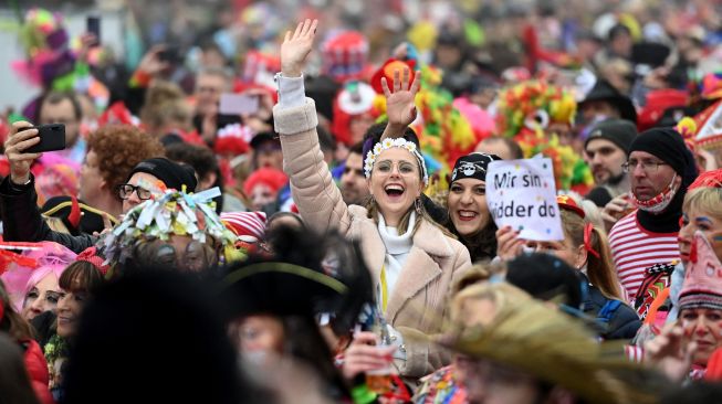 Orang-orang bersuka ria merayakan dimulainya musim karnaval "kelima" atau karnaval konyol di Cologne, Jerman, Jumat (11/11/2022). [INA FASSBENDER / AFP]